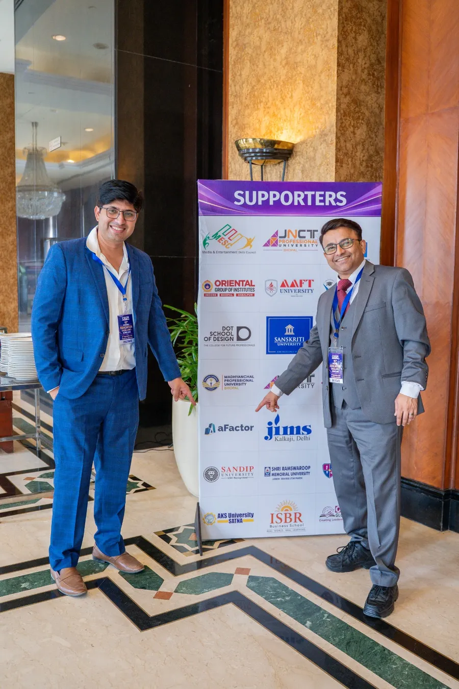 Amit Tiwari and Dr. Nandan Gijare point to the aFactor logo at the conclave